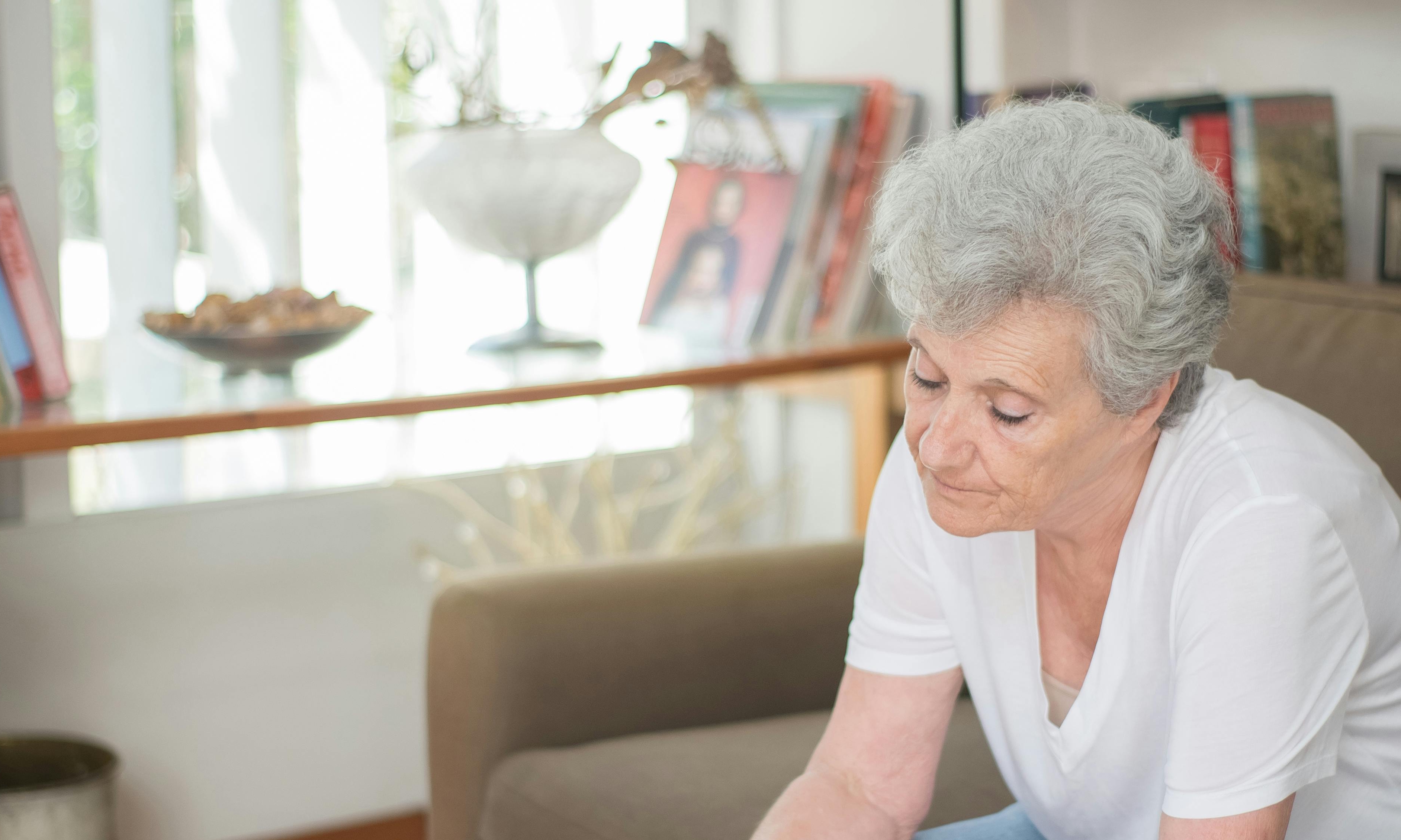 An elderly woman looking down thoughtfully | Source: Pexels