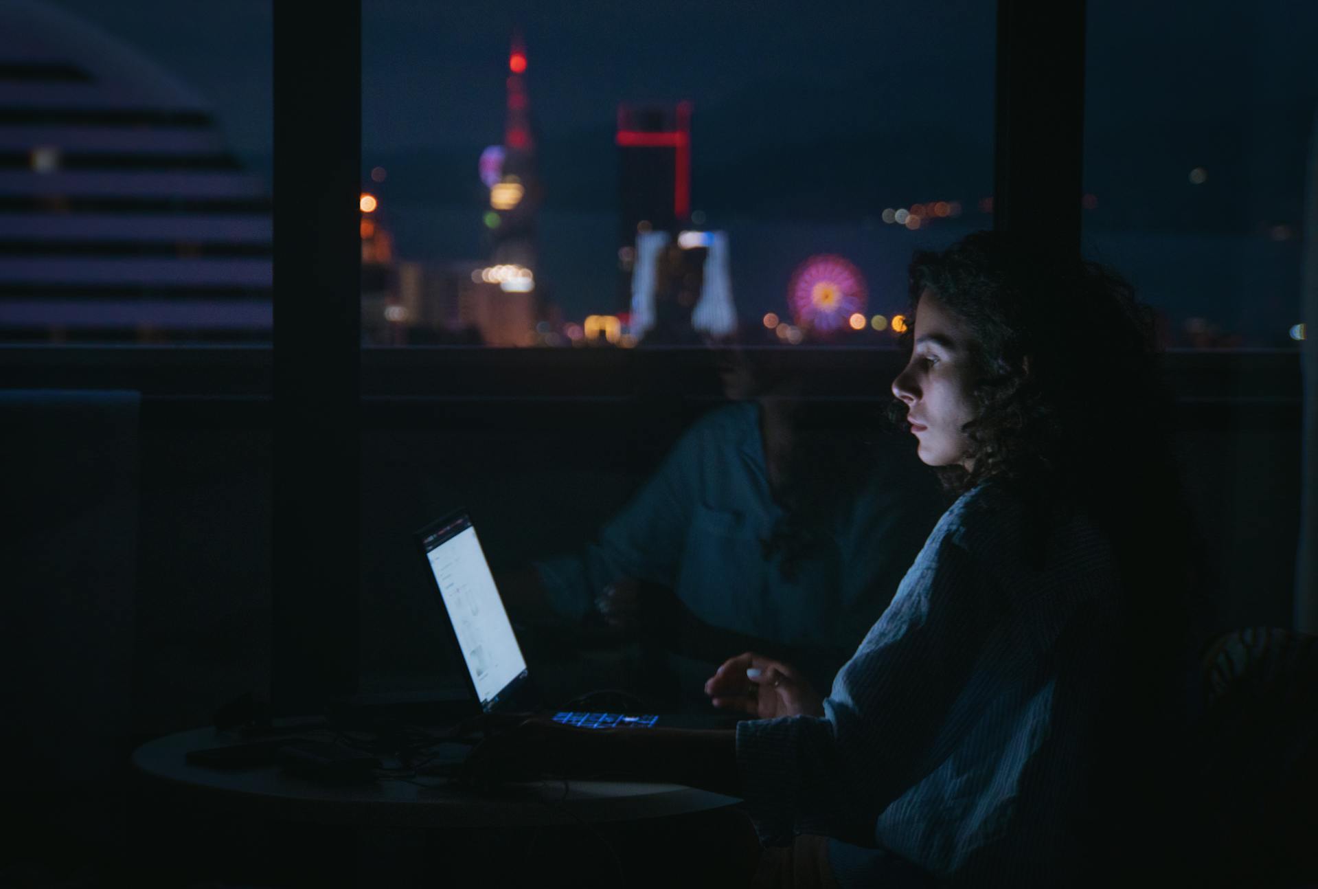 A woman using her laptop in the dark | Source: Pexels