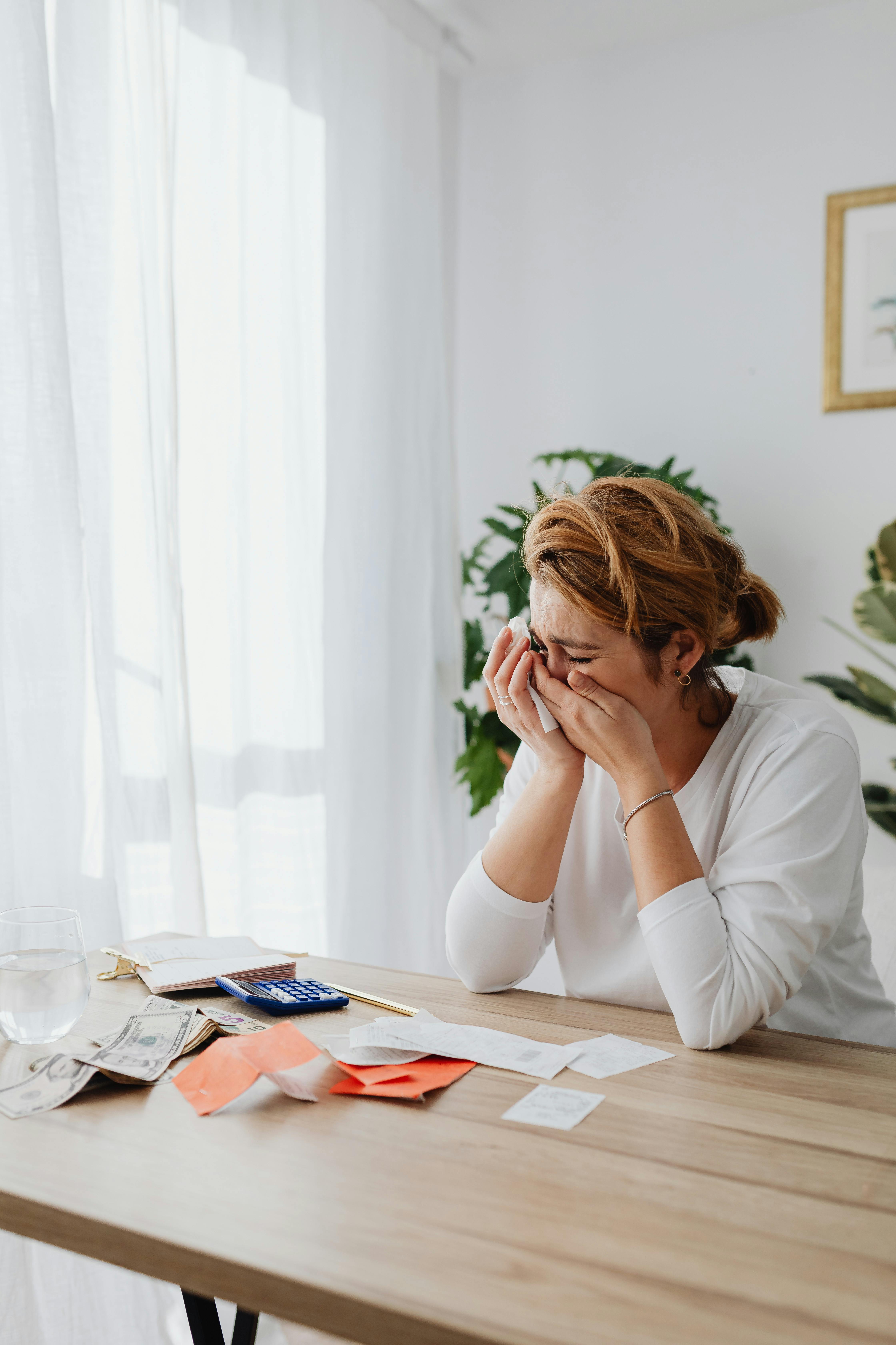 A woman crying while doing paperwork | Source: Pexels