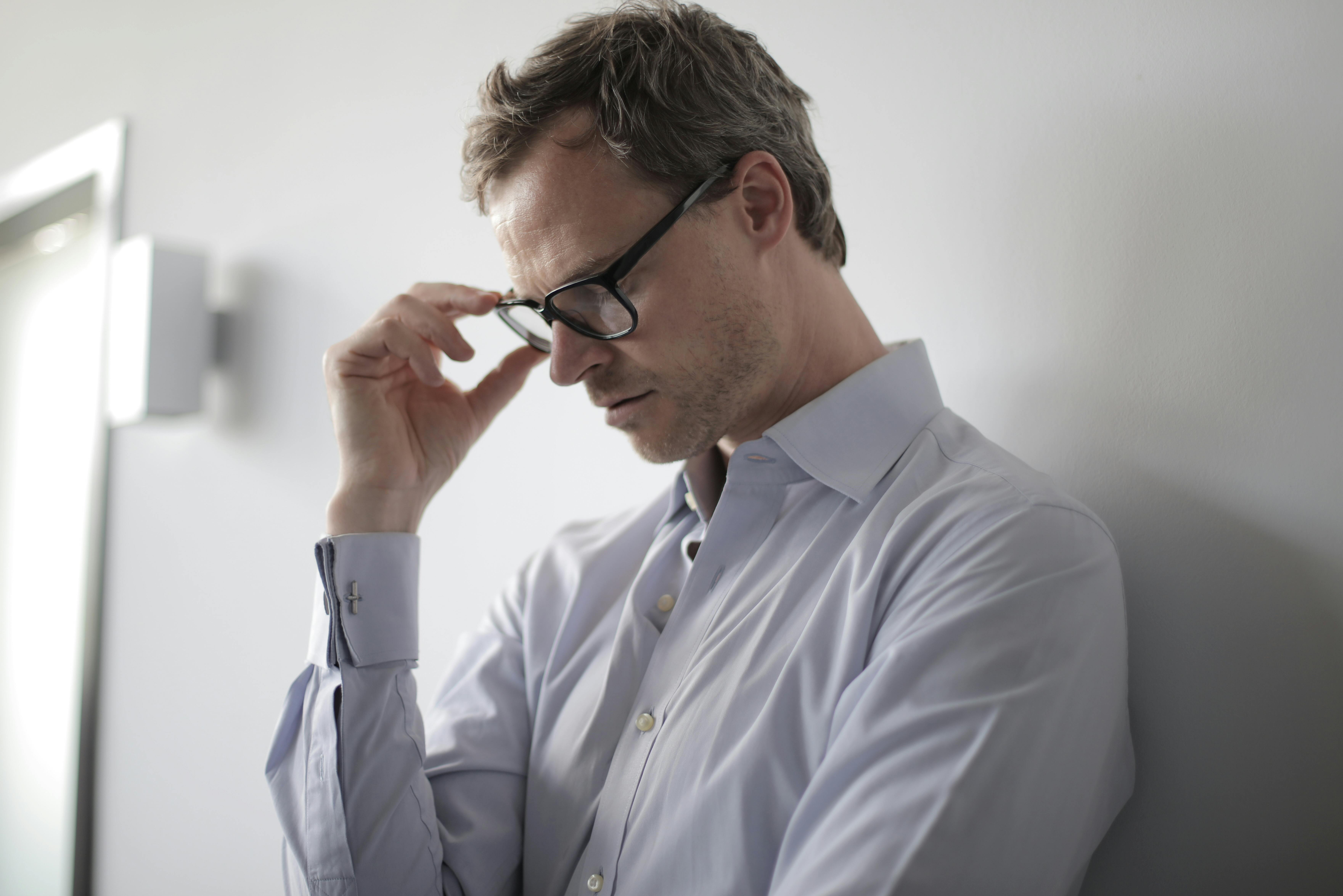 An upset man standing against a wall | Source: Pexels