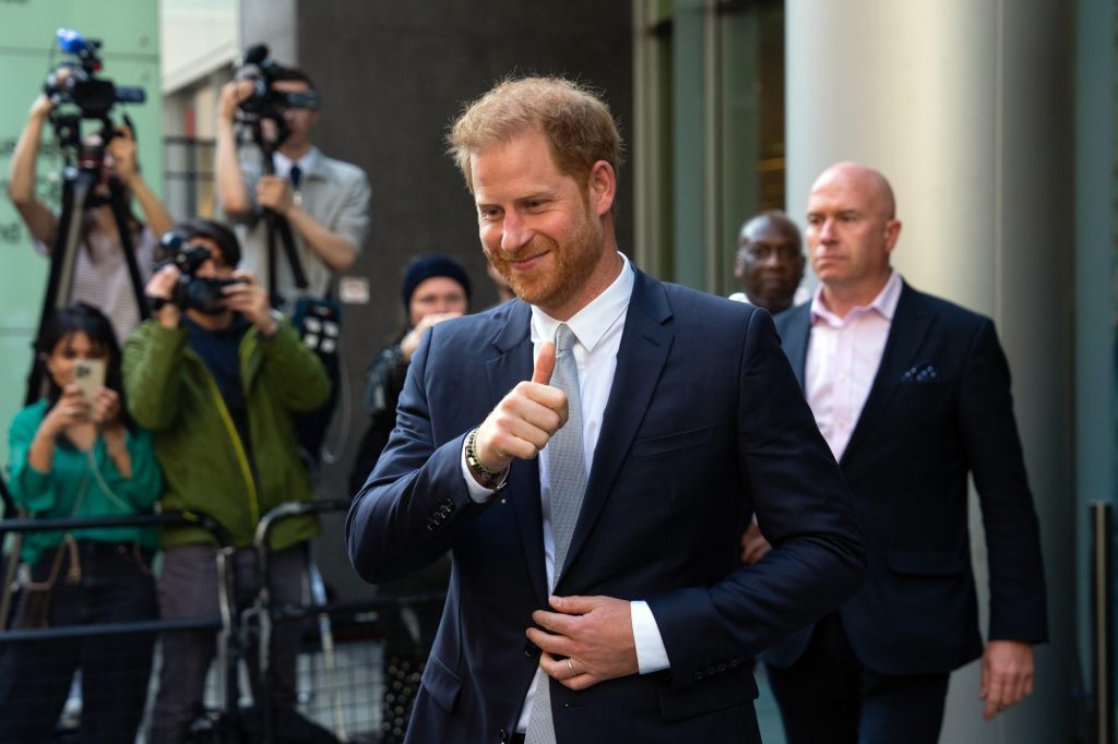 Prince Harry in a suit giving a thumbs up after giving evidence at the Mirror Group Newspapers trial at the Rolls Building, High Court in London