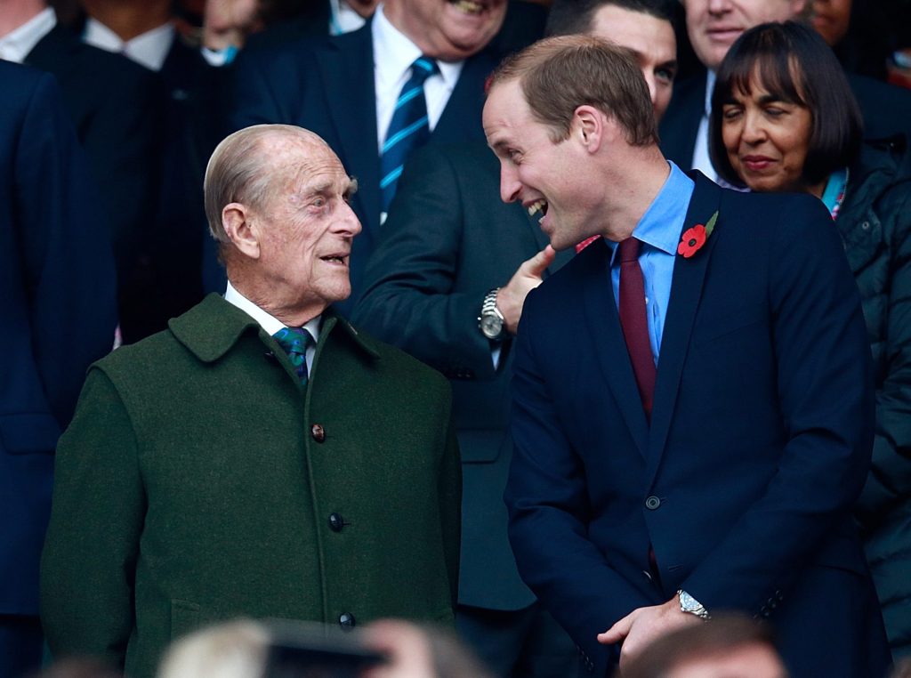 Princes Philip and William laughing together at the 2015 Rugby World Cup Final in Twickenham Stadium, London.