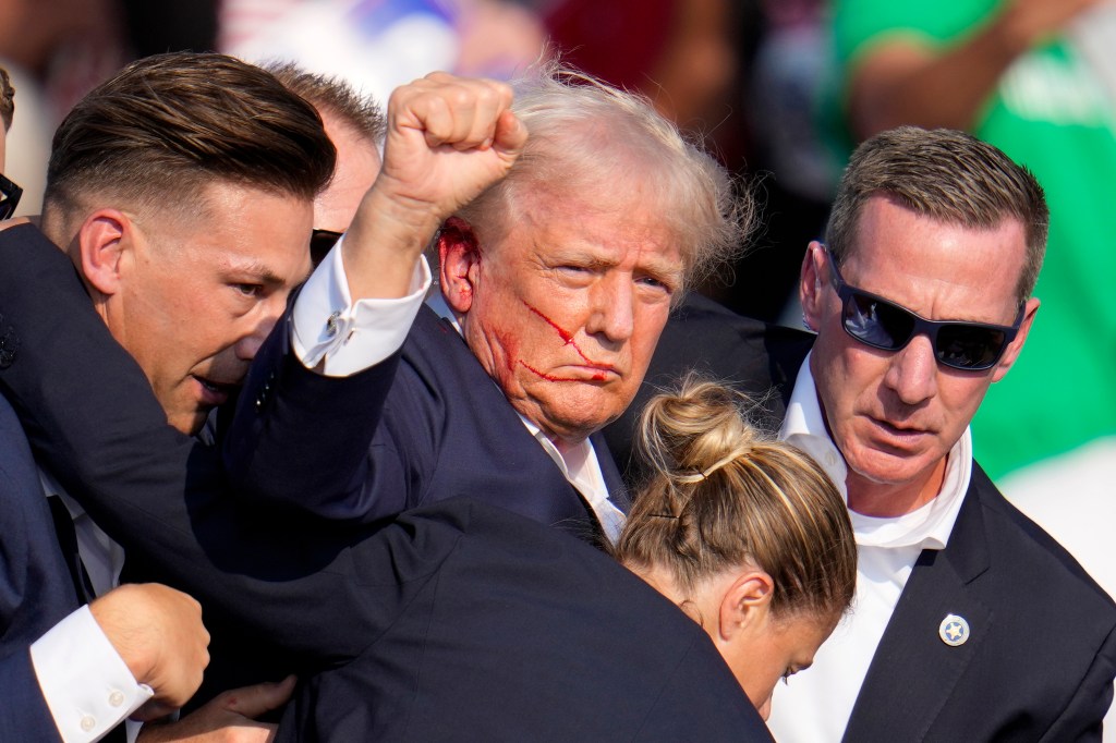 Trump raised a fist to the crowd as the Secret Service ushered him off stage.