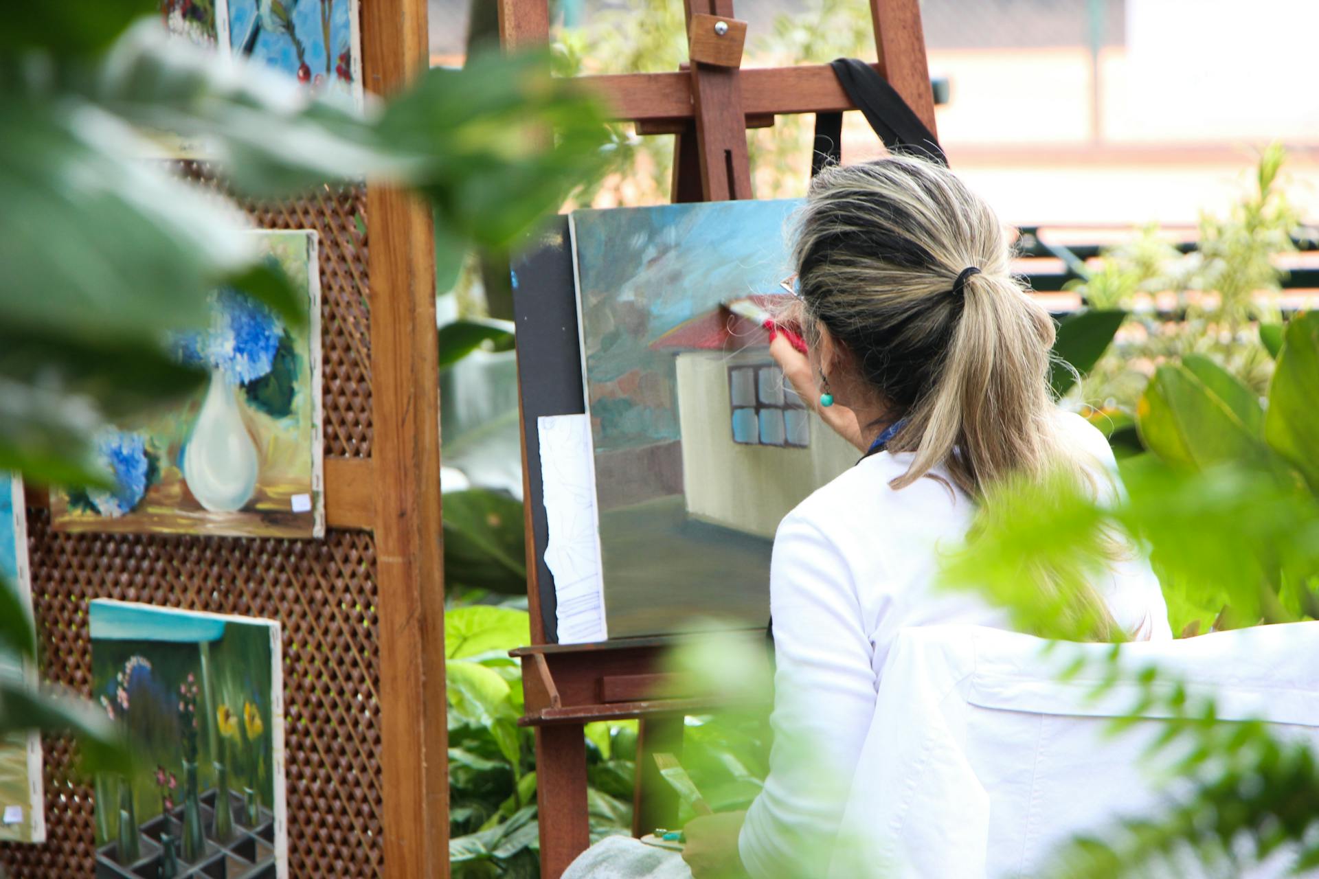 Rear view of a woman painting a picture in the garden | Source: Pexels