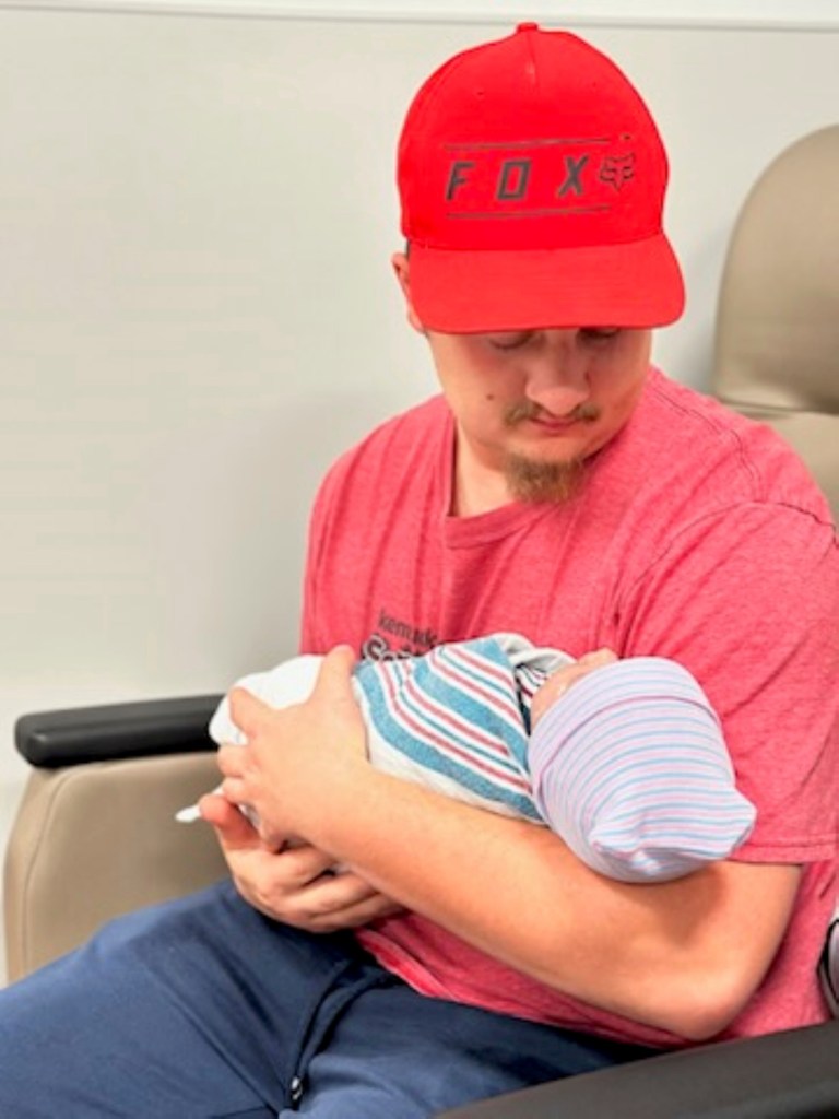 Christian Dellaquila holds his daughter, Willow Jade Dellaquila, hours after she was born in October 2023, in La Grange, Ky